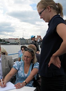 Anna Lyytinen-Sunell allekirjoittaa lippulaskua laivan kannella. Kuva: Kaisa Erola/YLE.