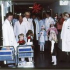 "Ohessa kirurgi-isäni Hannu Myllärniemen ottama kuva todennäköisesti  jouluaattona 1973 Meilahden sairaalan 2. kirurgian klinikan  perinteiseltä joulukierrolta, jonne henkilökunnan perheetkin saivat  osallistua. Meilahden tornisairaalan restaurointi on käynnissä ja  julkisivuremontti näyttää jo olevan lähes valmis.  Kuvan oikeassa laidassa olen itse isosiskoni Kati Myllärniemen kanssa  sairaanhoitajan asuissa. Muiden kuvassa olijoiden nimiä tai tietoja minulla ei valitettavasti ole." Lähettänyt: Marjukka My