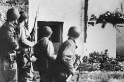 Kuva: Toinen maailmansota. Operaatio Overlord. Liittoutuneiden maihinnousu Normandiaan. Amerikkalainen joukko-osasto on valtaamassa kyl��. (1944) Wide World Photos.