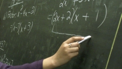 Kuva: Opettaja kirjoittaa laskutoimituksia liidulla liitutaululle (2001) AP Graphics Bank