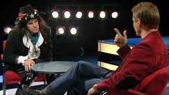 Kuva: Andy McCoyta imitoiva Jukka Puotila haastattelee Timo T. A. Mikkosta (2000). YLE kuvanauha.