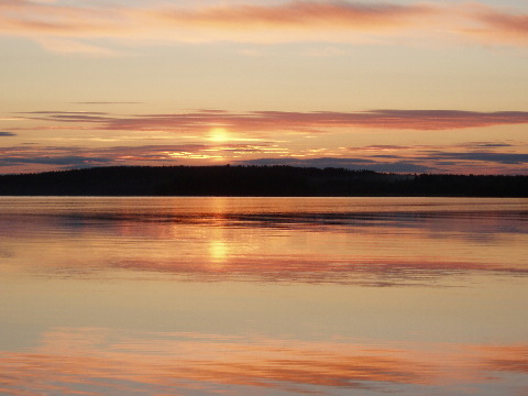 Keskiyön aurinko maalaa maisemaa.