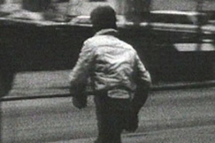 Kuva: Poika jouksee tien yli kohti kirjastoa. YLE kuvanauha. 