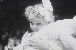 Kuva: Mallitytt�voittaja Sinikka Anneli katsoo voittoturkkinsa takaa. YLE kuvanauha. 