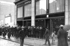 Kuva: Kieltolain kumoaminen. V�kijoukkoja alkoholimyym�l�n edess� liikkeen auettua. (1931) Kalle Kultala.