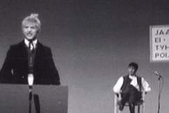 Kuva: Esko Salminen (etualalla) esitt�� eduskunnassa puhuvaa Nummisuutarin Eskoa. (1966) YLE kuvanauha. 