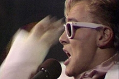 Kuva: Rele Kosunen laulaa Juppibluesia (1985). YLE kuvanauha.