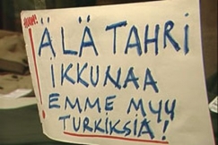 Kuva: Teksti vaateliikkeen ikkunassa (1995). YLE kuvanauha.
