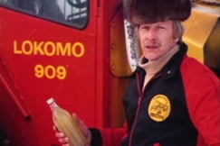 Kuva: Haastateltava n�ytt�� likaista polttoainetta sis�lt�v�� pulloa (1978). YLE kuvanauha.