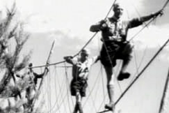 Kuva: Partiolainen ja partiojohtaja k�velev�t pitkin k�ysisiltaa (1958). YLE kuvanauha.