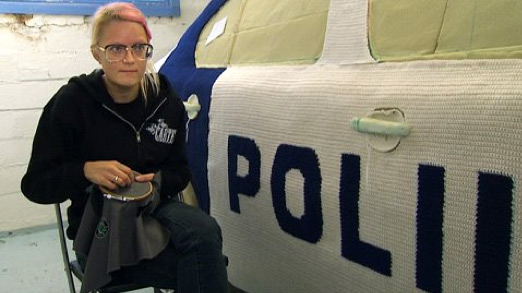 Kaija Papu virkatun poliisiautonsa vierellä